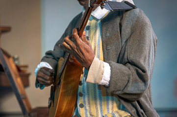 Musician wearing 17th century clothes performing on an 8-stringed mandolin
