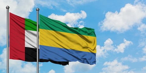 United Arab Emirates and Gabon flag waving in the wind against white cloudy blue sky together. Diplomacy concept, international relations.
