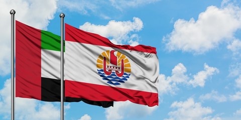 United Arab Emirates and French Polynesia flag waving in the wind against white cloudy blue sky together. Diplomacy concept, international relations.