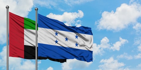 United Arab Emirates and Honduras flag waving in the wind against white cloudy blue sky together. Diplomacy concept, international relations.
