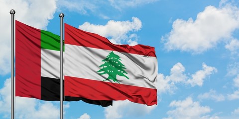 United Arab Emirates and Lebanon flag waving in the wind against white cloudy blue sky together. Diplomacy concept, international relations.