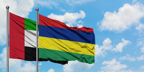 United Arab Emirates and Mauritius flag waving in the wind against white cloudy blue sky together. Diplomacy concept, international relations.