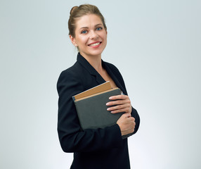Smiling woman teacher wearing black suit holding books.