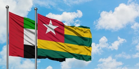 United Arab Emirates and Togo flag waving in the wind against white cloudy blue sky together. Diplomacy concept, international relations.