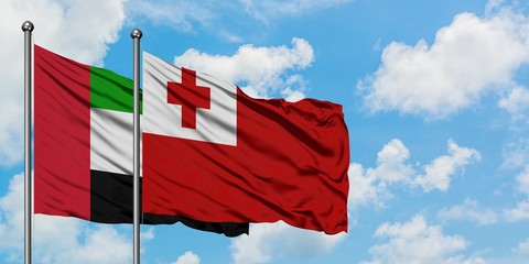 United Arab Emirates and Tonga flag waving in the wind against white cloudy blue sky together. Diplomacy concept, international relations.