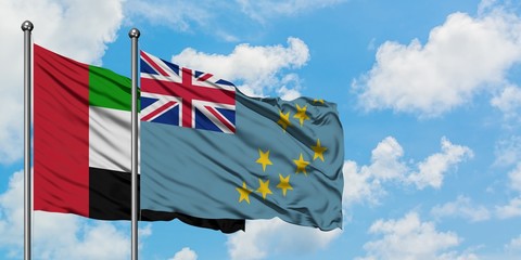 United Arab Emirates and Tuvalu flag waving in the wind against white cloudy blue sky together. Diplomacy concept, international relations.