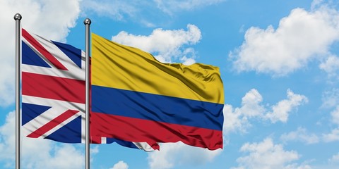 United Kingdom and Colombia flag waving in the wind against white cloudy blue sky together. Diplomacy concept, international relations.