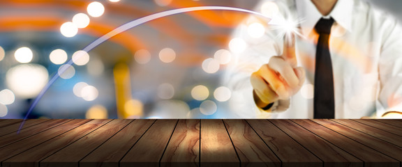 wooden table with blurred businessman plan business growth and chart of indicators and bokeh...