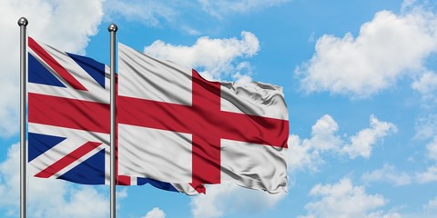 United Kingdom and England flag waving in the wind against white cloudy blue sky together. Diplomacy concept, international relations.