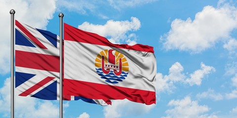 United Kingdom and French Polynesia flag waving in the wind against white cloudy blue sky together. Diplomacy concept, international relations.