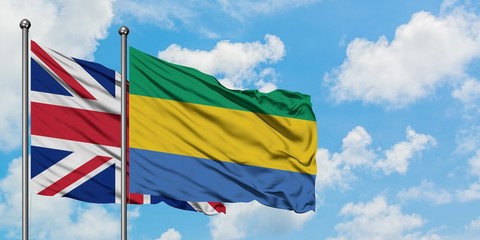 United Kingdom and Gabon flag waving in the wind against white cloudy blue sky together. Diplomacy concept, international relations.