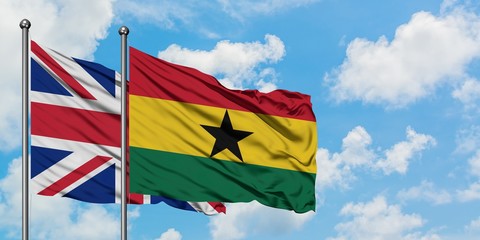 United Kingdom and Ghana flag waving in the wind against white cloudy blue sky together. Diplomacy concept, international relations.