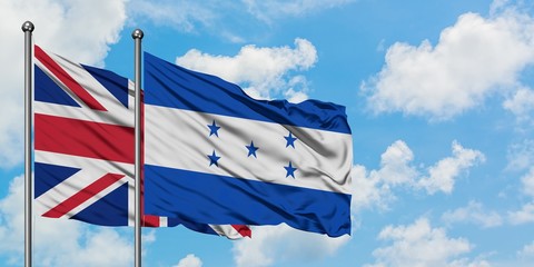 United Kingdom and Honduras flag waving in the wind against white cloudy blue sky together. Diplomacy concept, international relations.
