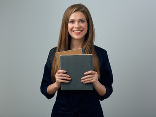 smiling woman teacher in black dress holding exercise books