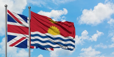 United Kingdom and Kiribati flag waving in the wind against white cloudy blue sky together. Diplomacy concept, international relations.