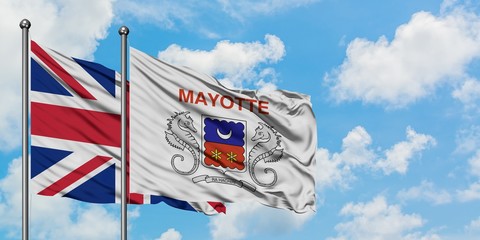 United Kingdom and Mayotte flag waving in the wind against white cloudy blue sky together. Diplomacy concept, international relations.