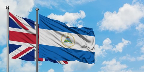 United Kingdom and Nicaragua flag waving in the wind against white cloudy blue sky together. Diplomacy concept, international relations.