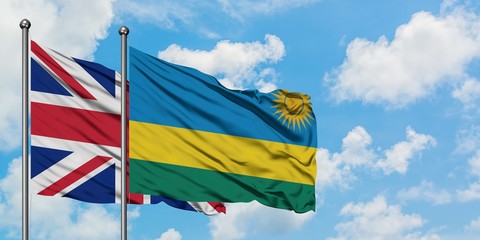 United Kingdom and Rwanda flag waving in the wind against white cloudy blue sky together. Diplomacy concept, international relations.