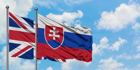 United Kingdom and Slovakia flag waving in the wind against white cloudy blue sky together. Diplomacy concept, international relations.