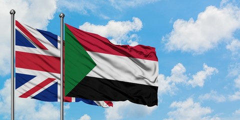 United Kingdom and Sudan flag waving in the wind against white cloudy blue sky together. Diplomacy concept, international relations.