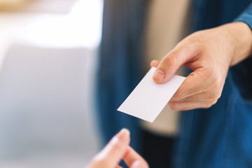 Fototapeta premium Businessman holding and giving empty business card