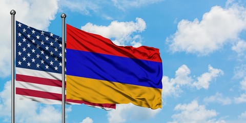 United States and Armenia flag waving in the wind against white cloudy blue sky together. Diplomacy concept, international relations.