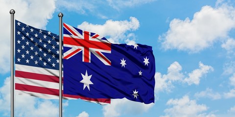 United States and Australia flag waving in the wind against white cloudy blue sky together. Diplomacy concept, international relations.