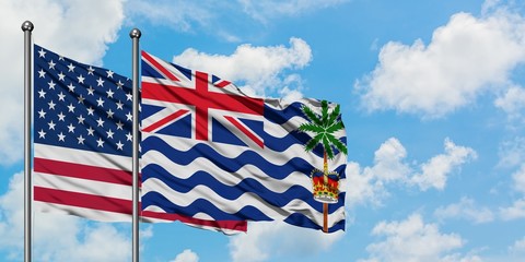 United States and British Indian Ocean Territory flag waving in the wind against white cloudy blue sky together. Diplomacy concept, international relations.