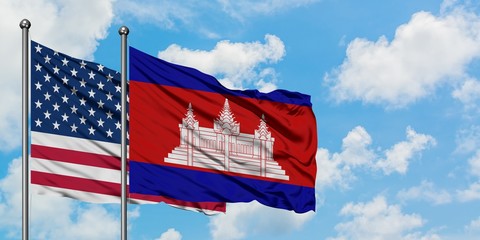 United States and Cambodia flag waving in the wind against white cloudy blue sky together. Diplomacy concept, international relations.