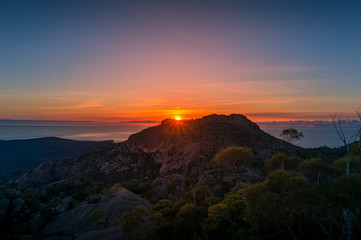 Mountain sunrise landscape. Mountain peak with sun raising above the rock