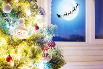 Christmas home room with tree and moon lighting in window. The elements of this image furnished by NASA Decorating and christmas tree