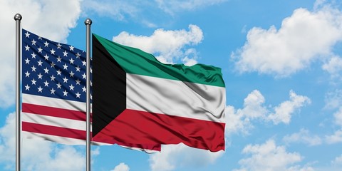 United States and Kuwait flag waving in the wind against white cloudy blue sky together. Diplomacy concept, international relations.