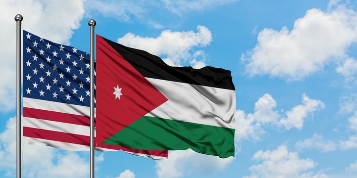 United States and Jordan flag waving in the wind against white cloudy blue sky together. Diplomacy concept, international relations.