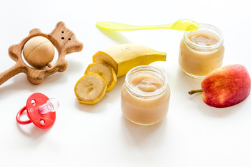 Fruity baby food with apple and banana on white background