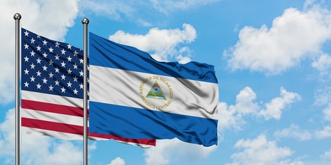 United States and Nicaragua flag waving in the wind against white cloudy blue sky together. Diplomacy concept, international relations.