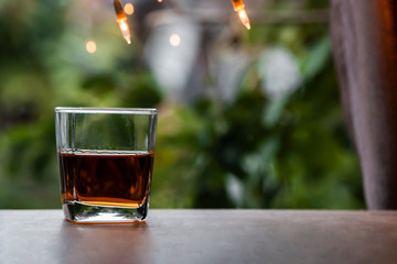 a glass of whiskey on wood bar, soft focus.	