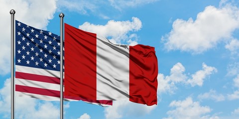 United States and Peru flag waving in the wind against white cloudy blue sky together. Diplomacy concept, international relations.