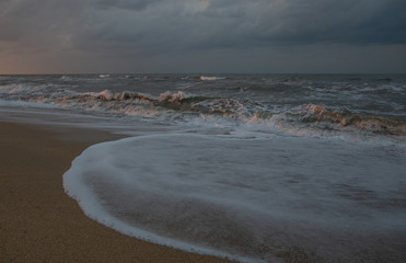 sunset at sea during a storm on the shore of a fishing boat