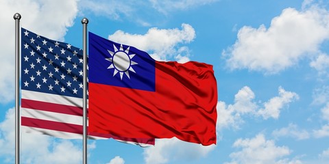 United States and Taiwan flag waving in the wind against white cloudy blue sky together. Diplomacy concept, international relations.