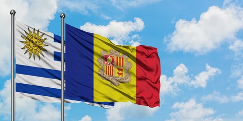 Uruguay and Andorra flag waving in the wind against white cloudy blue sky together. Diplomacy concept, international relations.