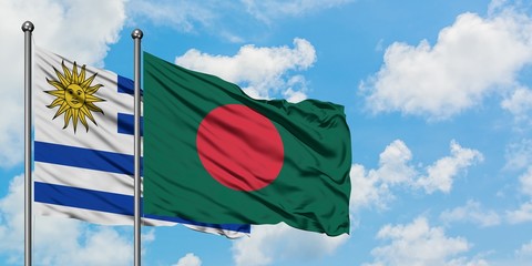 Uruguay and Bangladesh flag waving in the wind against white cloudy blue sky together. Diplomacy concept, international relations.