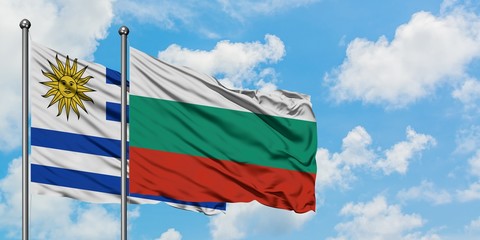 Uruguay and Bulgaria flag waving in the wind against white cloudy blue sky together. Diplomacy concept, international relations.