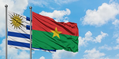 Uruguay and Burkina Faso flag waving in the wind against white cloudy blue sky together. Diplomacy concept, international relations.