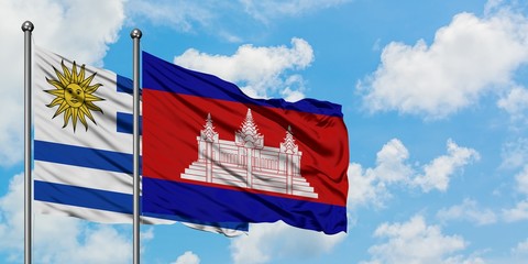 Uruguay and Cambodia flag waving in the wind against white cloudy blue sky together. Diplomacy concept, international relations.