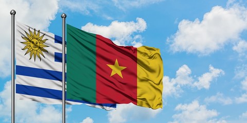 Uruguay and Cameroon flag waving in the wind against white cloudy blue sky together. Diplomacy concept, international relations.