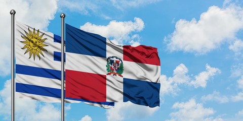 Uruguay and Dominican Republic flag waving in the wind against white cloudy blue sky together. Diplomacy concept, international relations.