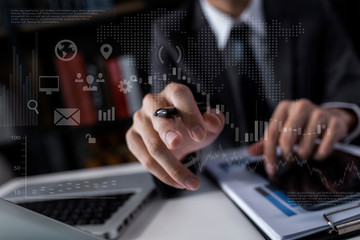 Double exposure of business people hands with laptop and stock market graph background.