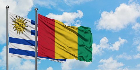Uruguay and Guinea flag waving in the wind against white cloudy blue sky together. Diplomacy concept, international relations.