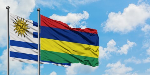 Uruguay and Mauritius flag waving in the wind against white cloudy blue sky together. Diplomacy concept, international relations.