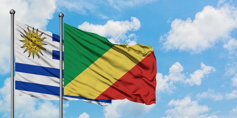 Uruguay and Republic Of The Congo flag waving in the wind against white cloudy blue sky together. Diplomacy concept, international relations.